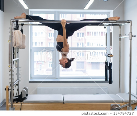 Caucasian woman doing pilates on reformer.  134794727