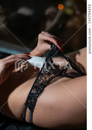 Woman using white clitoral vacuum stimulator.  134794858