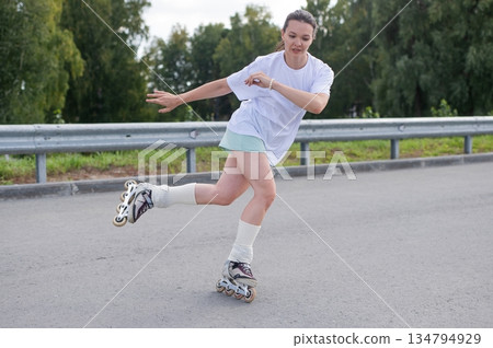 Caucasian woman rollerblading fast on road.  134794929