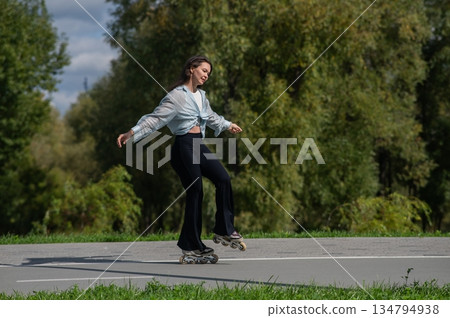Caucasian woman roller skating in park. Caucasian woman roller skating in park. 134794938