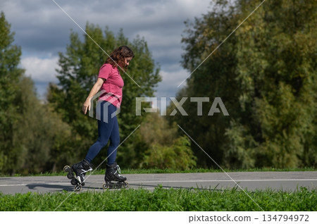 Caucasian woman roller skating in park. Caucasian woman roller skating in park. 134794972