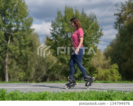 Caucasian woman roller skating in park.  134794976