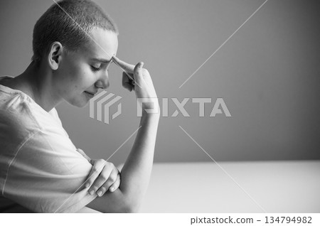 Portrait of a sad young woman sitting at a table on a white background. Copy space Portrait of a sad young woman sitting at a table on a white background. Copy space 134794982