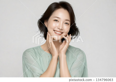 Woman with a green shirt is smiling and showing her teeth Woman with a green shirt is smiling and showing her teeth 134796063