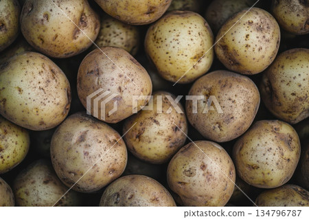 Close Up of Stacked Golden Brown Potatoes on a Dark Background 134796787