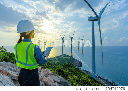 Technician in Neon Green Vest Inspecting Wind Farm Turbines by the Ocean Technician in Neon Green Vest Inspecting Wind Farm Turbines by the Ocean 134796978