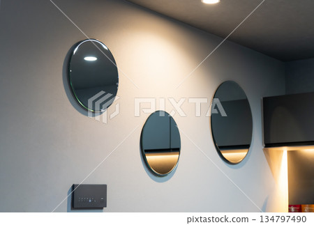 客廳牆上掛著一面時尚漂亮的圓形鏡子。 134797490