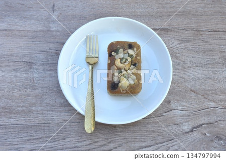 butter banana cake topping peanut and whole grain couple raisin with golden fork on plate 134797994