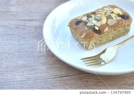 butter banana cake topping peanut and whole grain couple raisin with golden fork on plate 134797995