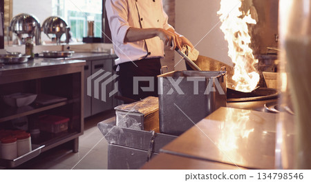 professional chef stands and working in a modern kitchen, wearing a white uniform. This image conveys expertise, focus, and readiness in a high demand culinary environment for restaurant profile professional chef stands and working in a modern kitchen, wearing a white uniform. This image conveys expertise, focus, and readiness in a high demand culinary environment for restaurant profile 134798546