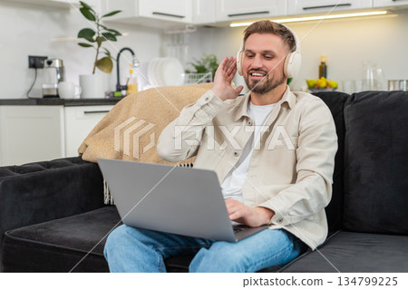Young man works on laptop with calm music playing focus and productivity relaxed mood ambient tune 134799225