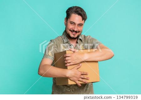 Man hugging cardboard delivery box happy smile expressing excitement about received online package 134799319