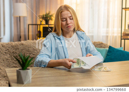 Young woman sorts money cash separating portions planning financial obligations, future expenses 134799668
