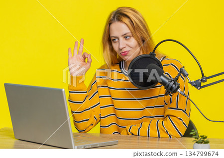 Blogger woman influencer recording podcast giving workshop webinar speaking in microphone and laptop 134799674