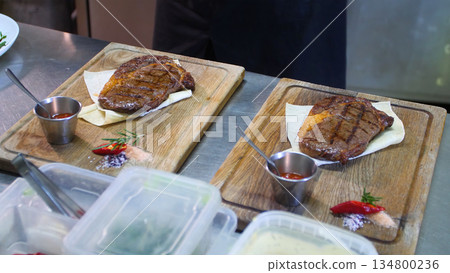 Steakhouse. Steaks are roasted on a Josper oven. The chef serves steaks on wooden boards 134800236