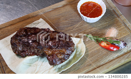Steakhouse. Steaks are roasted on a Josper oven. The chef serves steaks on wooden boards Steakhouse. Steaks are roasted on a Josper oven. The chef serves steaks on wooden boards 134800285