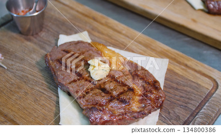 Steakhouse. Steaks are roasted on a Josper oven. The chef serves steaks on wooden boards 134800386