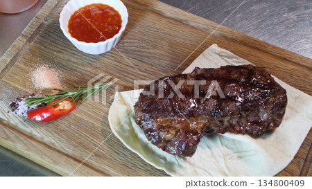 Steakhouse. Steaks are roasted on a Josper oven. The chef serves steaks on wooden boards Steakhouse. Steaks are roasted on a Josper oven. The chef serves steaks on wooden boards 134800409