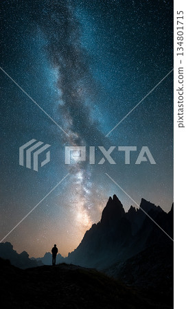 人們仰望夜空和銀河。雄偉的山脈和繁星點點的天空構成了一幅壯麗的景象。 134801715