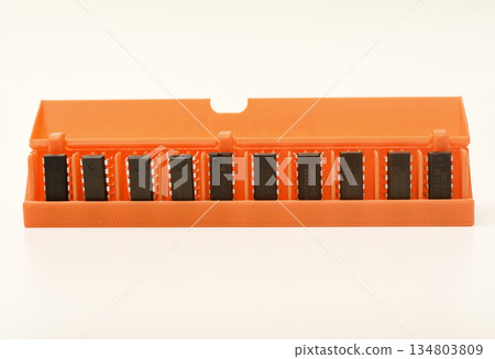 Microchips in a plastic case. Integrated circuits in a plastic storage case. Electronic chips. Microchips in a plastic case. Integrated circuits in a plastic storage case. Electronic chips. 134803809