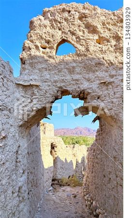Bright Path With Historic Charm, Sunlit Corridor Extending Beneath Azure Sky, Warm Sandcolored Trail Runs Between Mudbrick Boundaries Towards Luminous Horizon With Tranquil Historic Atmosphere 134803929