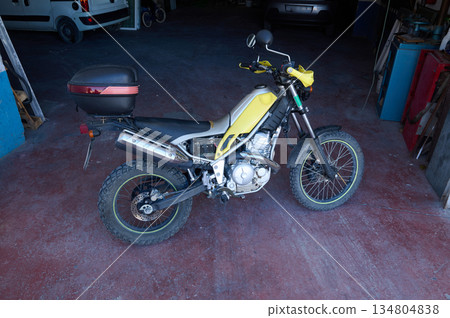 Yellow Dirt Bike With Top Case Parked In A Busy Workshop Garage For Adventure Riding Yellow Dirt Bike With Top Case Parked In A Busy Workshop Garage For Adventure Riding 134804838