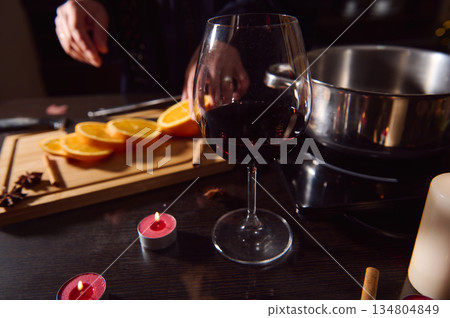 Elegant Evening Of Mulled Wine: Winter Holiday Cooking With Oranges, Candles, And Cozy Ambience Elegant Evening Of Mulled Wine: Winter Holiday Cooking With Oranges, Candles, And Cozy Ambience 134804849
