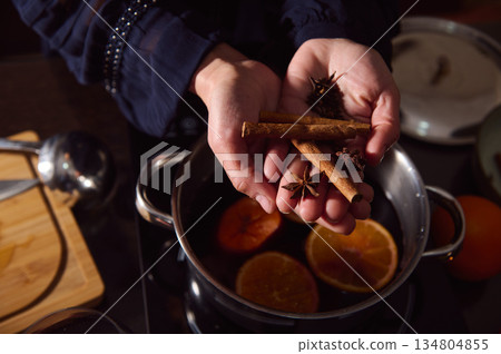 Warm Mulled Wine Preparation With Cinnamon Sticks And Star Anise In Cozy Winter Kitchen 134804855