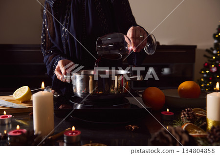 Elegant Woman In Evening Gown Preparing Mulled Wine For Winter Holidays By Candlelight 134804858