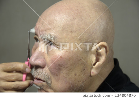 Old man eyebrow cutting 134804870