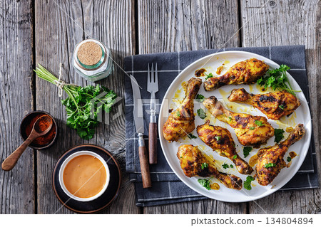 roasted chicken drumsticks on a white plate 134804894