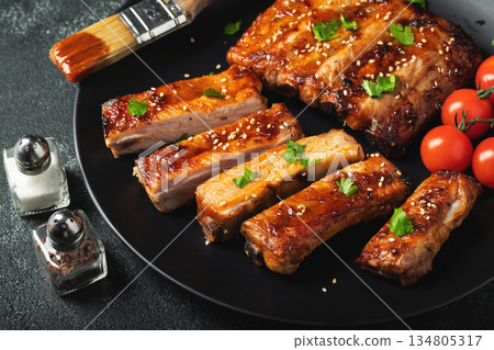 Hot grilled spare ribs from a summer BBQ served on a plate with sauce. Top view. Copy space Hot grilled spare ribs from a summer BBQ served on a plate with sauce. Top view. Copy space 134805317