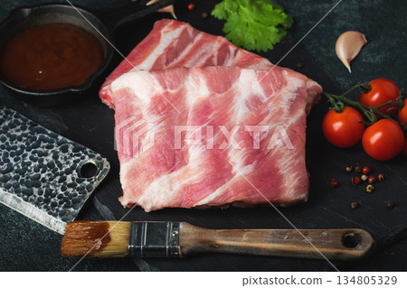 Raw meat. Raw pork ribs from the back with meat on a black background. background image 134805329