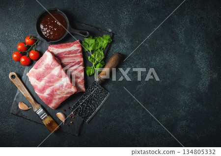 Raw meat. Raw pork ribs from the back with meat on a black background. background image 134805332
