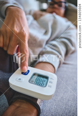 Person checking blood pressure for heart health at home Person checking blood pressure for heart health at home 134805604