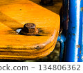 Close up of an old rusty bolt on a wooden board 134806362