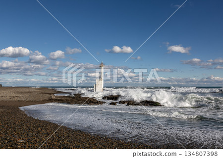A view of the light pole, waves and white clouds at Heitarohama Beach on Oarai Coast 134807398