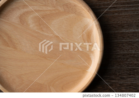 Close-up of a simple wooden round plate Close-up of a simple wooden round plate 134807402