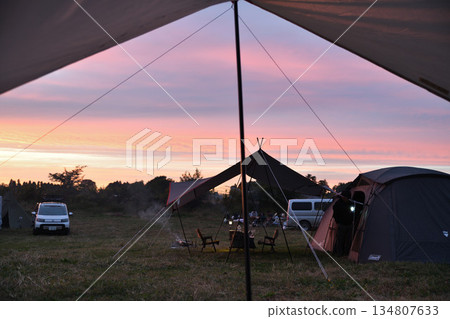 夕陽西下，天空和營地——透過防水布看到的帳篷 134807633