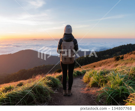 Solo hiker enjoying serene mountain sunrise with breathtaking view Solo hiker enjoying serene mountain sunrise with breathtaking view 134807768