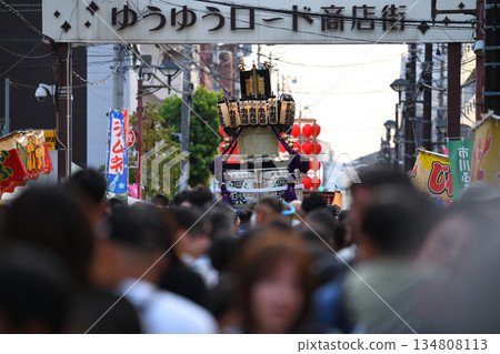 黃昏時分，市川站南側的商業街上，一座夏季祭典的移動神社和熙熙攘攘的人群正在穿梭。 134808113