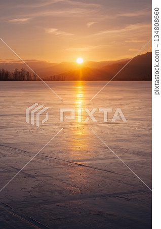 Beautiful sunset over a lake with a mountain in the background Beautiful sunset over a lake with a mountain in the background 134808660