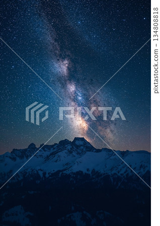 The night sky is filled with stars and a large mountain range in the background 134808818