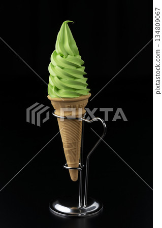 Matcha soft serve ice cream cone and metal stand on black background 134809067