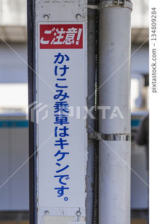 警示牌提醒乘客不要貿然衝上火車,以免發生危險。車站內的安全標誌。 警示牌提醒乘客不要貿然衝上火車,以免發生危險。車站內的安全標誌。 134809284