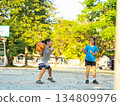 Two young girls playing basketball together on outdoor court 134809976