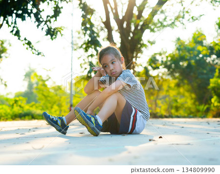 Portrait of exhausted young girl resting on the ground after sports activity. Portrait of exhausted young girl resting on the ground after sports activity. 134809990