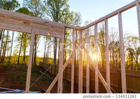 Workers build wooden beams frame of new house in forest area Workers build wooden beams frame of new house in forest area 134811261