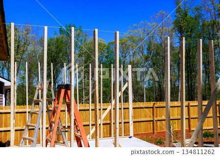 Workers build wooden beams framework in backyard with renovation house Workers build wooden beams framework in backyard with renovation house 134811262