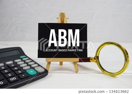 ABM abbreviation of Account Based Marketing text with magnifying glass and calculator on wooden background ABM abbreviation of Account Based Marketing text with magnifying glass and calculator on wooden background 134813662